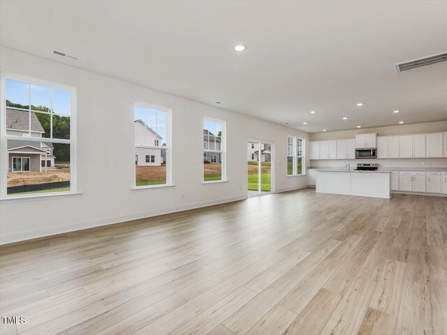 unfurnished living room featuring recessed lighting, baseboards, visible vents, and light wood finished floors