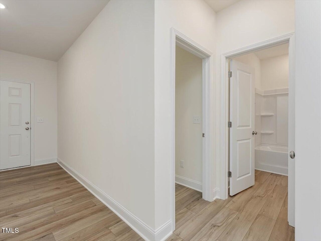 hallway with light wood-style floors and baseboards