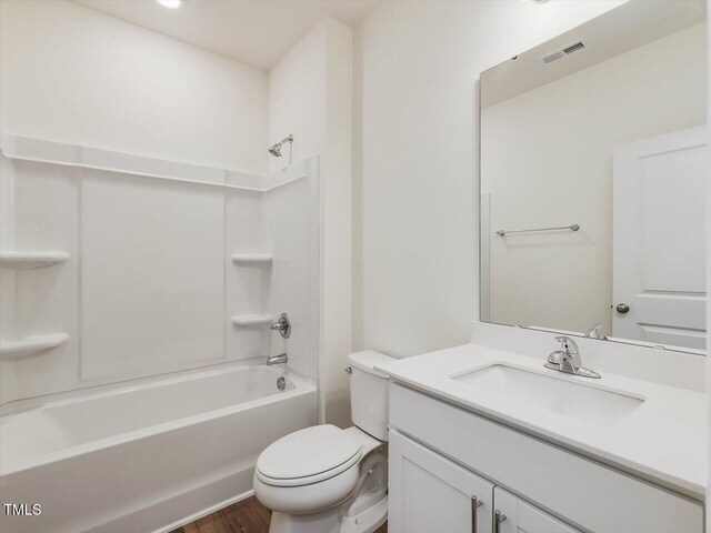 bathroom featuring shower / bathtub combination, visible vents, toilet, vanity, and wood finished floors