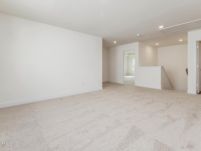 spare room featuring light carpet, baseboards, attic access, and recessed lighting