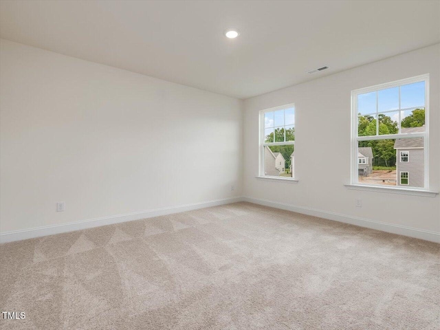 unfurnished room featuring recessed lighting, light colored carpet, visible vents, and baseboards