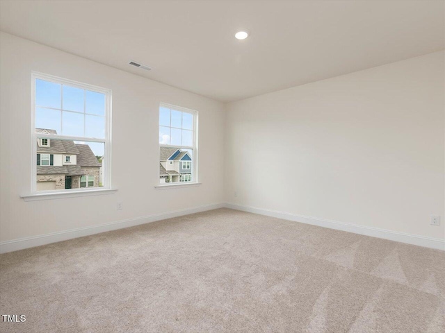 carpeted empty room featuring visible vents, baseboards, and recessed lighting