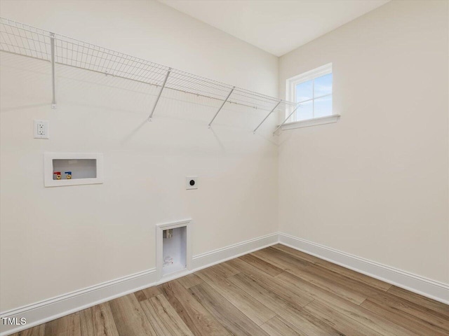 clothes washing area featuring laundry area, wood finished floors, hookup for a washing machine, and baseboards