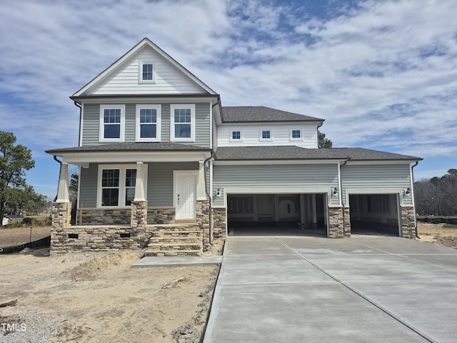 view of front of house with a porch, a garage, a shingled roof, driveway, and stone siding