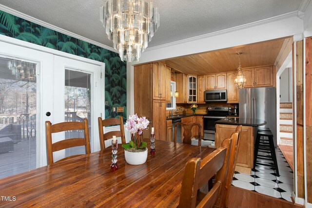 dining space featuring french doors, crown molding, sink, a textured ceiling, and light hardwood / wood-style floors