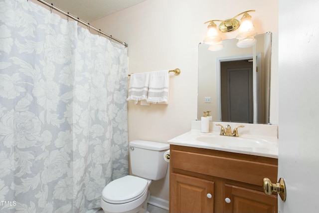 bathroom with vanity, toilet, and a textured ceiling