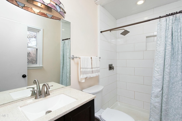 bathroom with a shower with shower curtain, vanity, and toilet