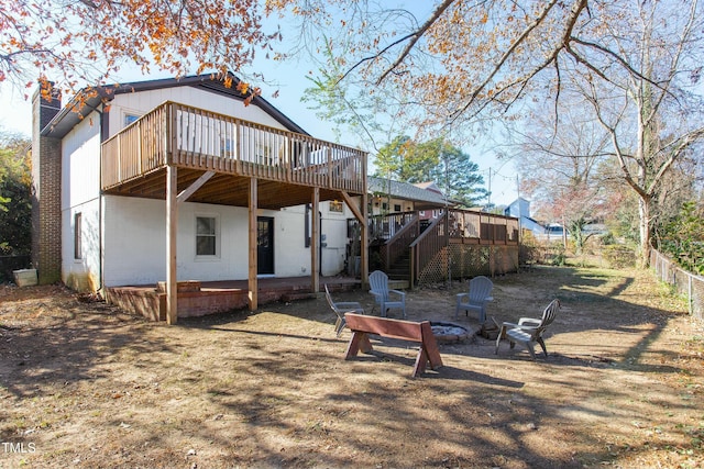 rear view of property featuring a deck and an outdoor fire pit