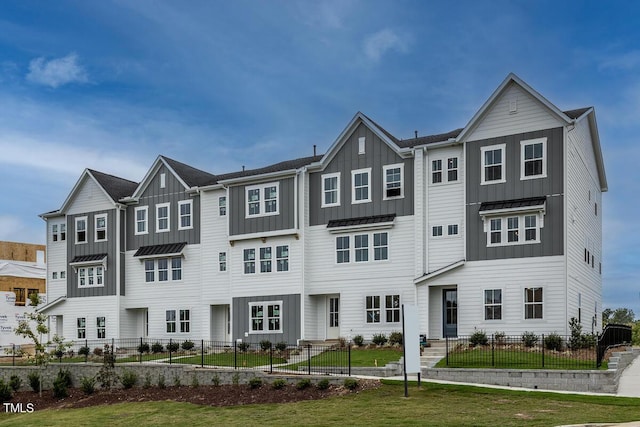 townhome / multi-family property with a standing seam roof, board and batten siding, and metal roof