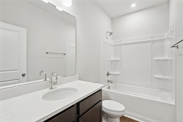 bathroom with tub / shower combination, toilet, wood finished floors, and vanity