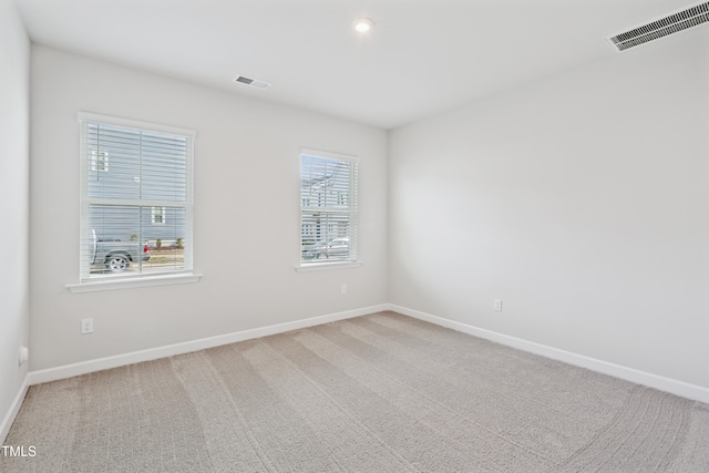 carpeted spare room with baseboards and visible vents