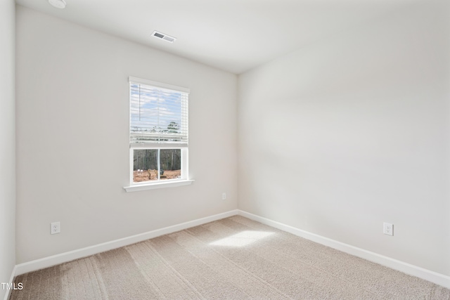 carpeted empty room with visible vents and baseboards