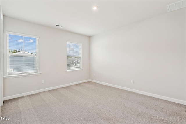 unfurnished room with visible vents, carpet floors, and baseboards