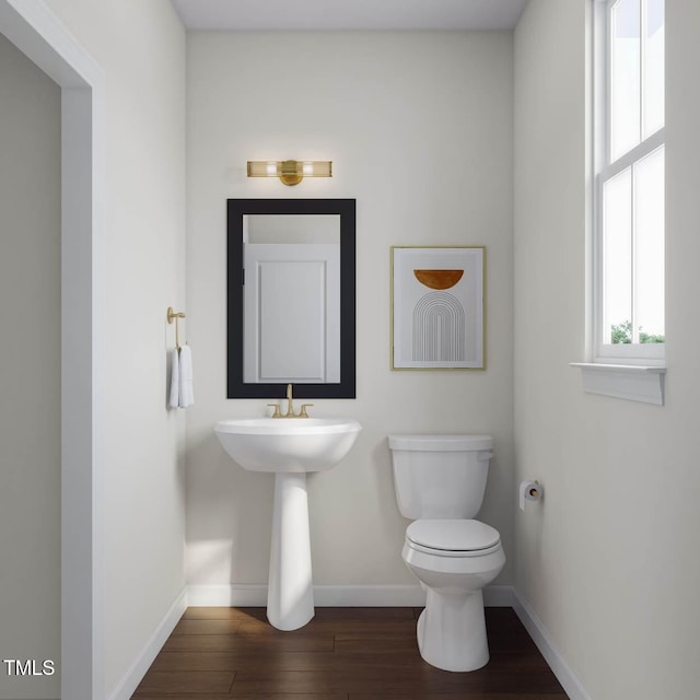 half bathroom featuring toilet, baseboards, and wood finished floors