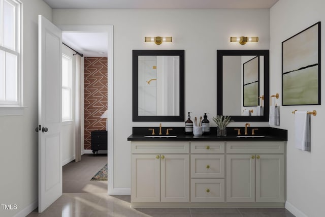 full bathroom featuring a sink, baseboards, and double vanity