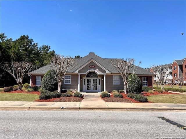 view of front of home with french doors and a front lawn