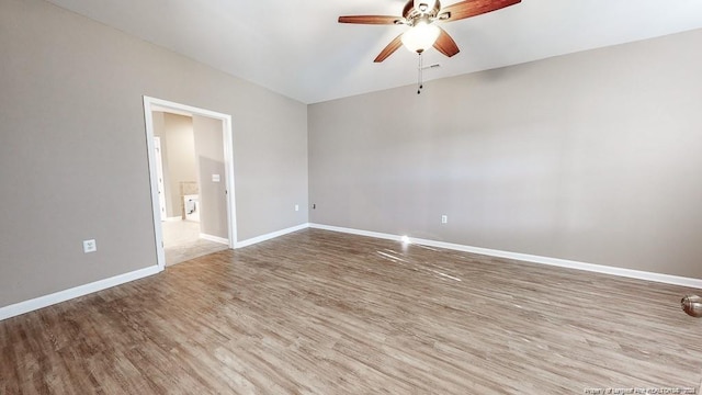 empty room featuring ceiling fan, baseboards, and wood finished floors