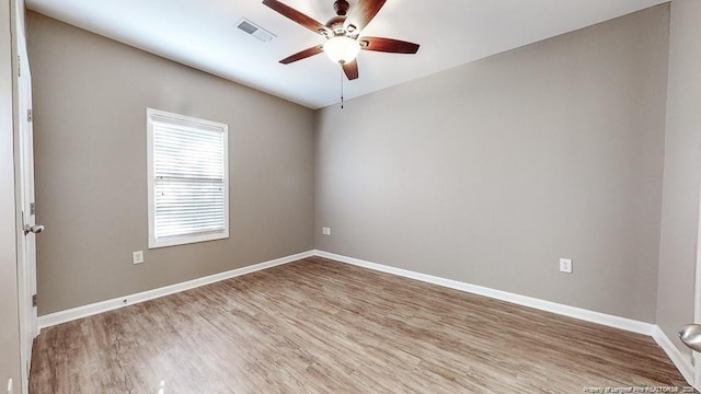 empty room featuring visible vents, baseboards, ceiling fan, and wood finished floors