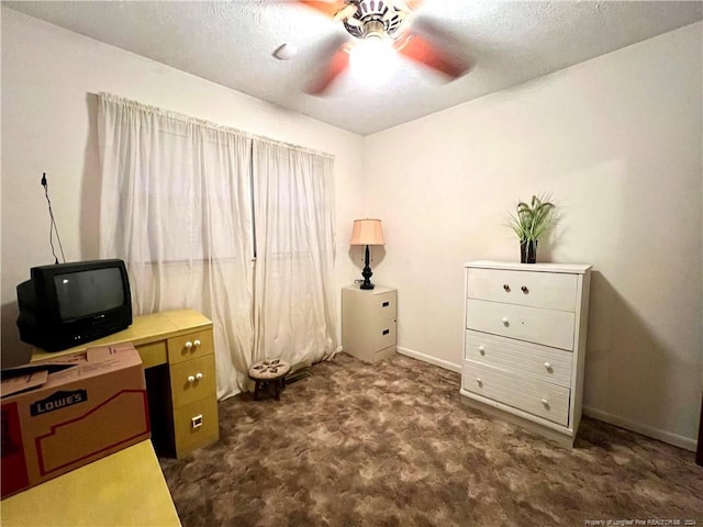 office space with a textured ceiling, dark carpet, and ceiling fan