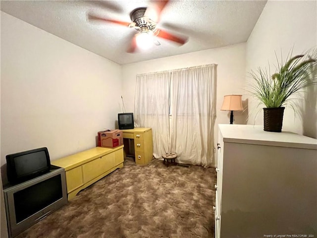 office with dark colored carpet, a textured ceiling, and ceiling fan