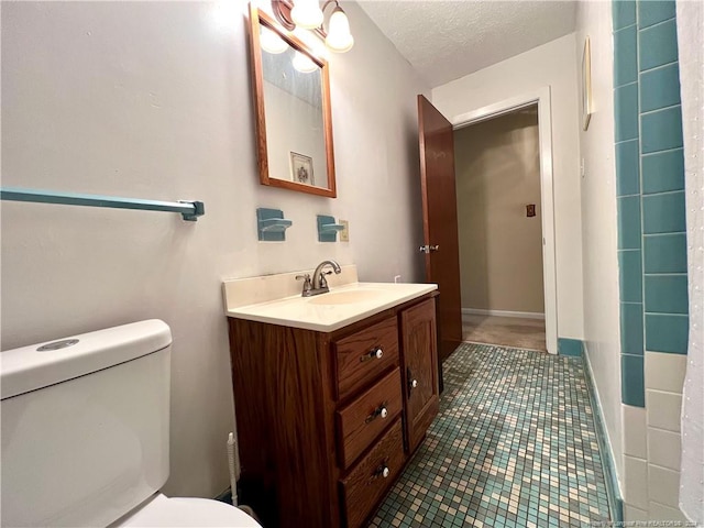 bathroom featuring tile patterned floors, vanity, a textured ceiling, and toilet