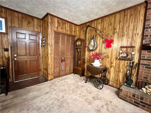 interior space with wood walls, dark carpet, crown molding, and a textured ceiling