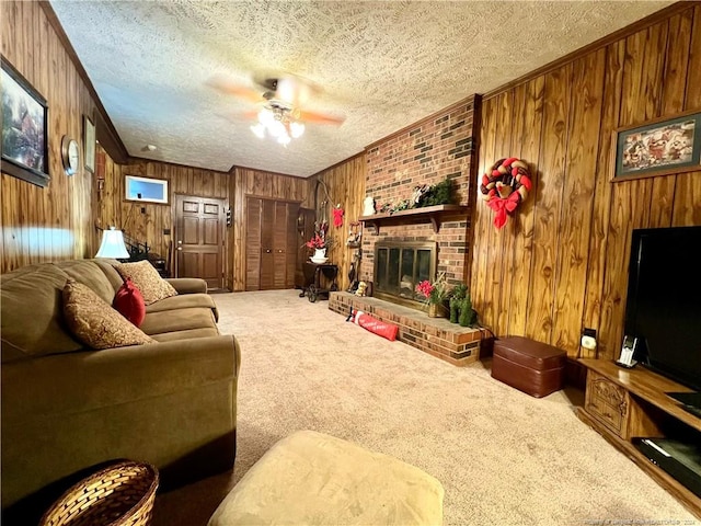 living room featuring ceiling fan, carpet floors, a textured ceiling, and wooden walls