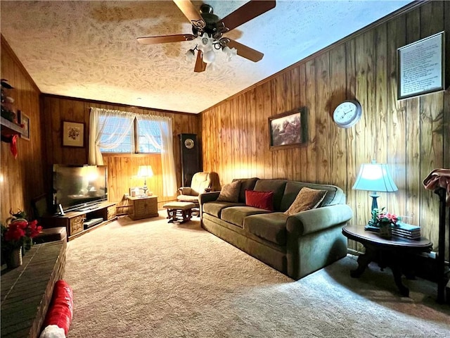 living room with carpet flooring, ornamental molding, a textured ceiling, ceiling fan, and wooden walls