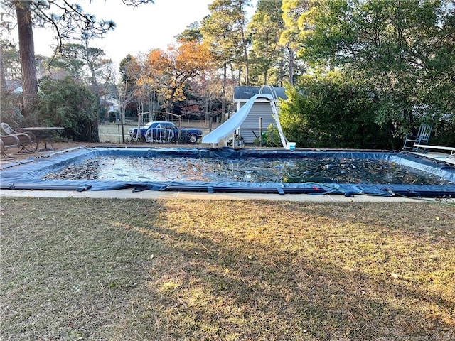 view of pool with a yard and a water slide