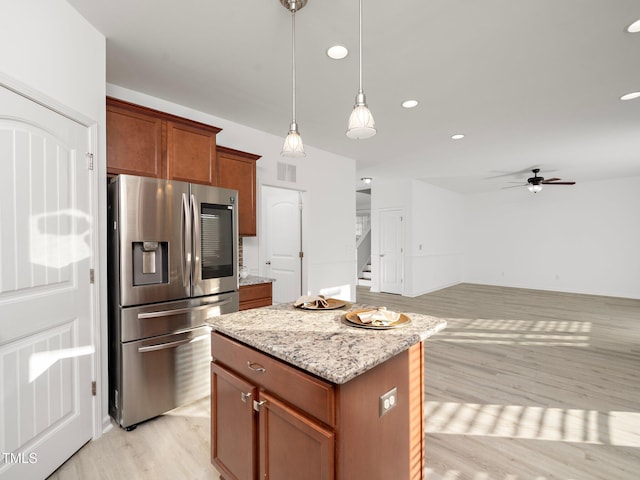 kitchen with ceiling fan, a center island, stainless steel refrigerator with ice dispenser, and light hardwood / wood-style flooring