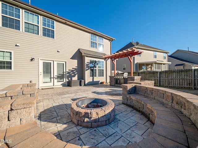 rear view of house featuring a pergola, french doors, a patio, and an outdoor fire pit