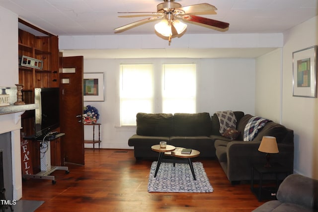 living room featuring ceiling fan and dark hardwood / wood-style flooring