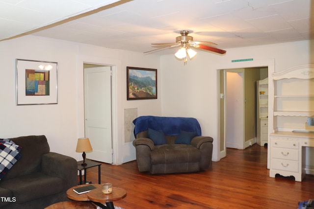 living room with dark hardwood / wood-style floors, ceiling fan, and ornamental molding