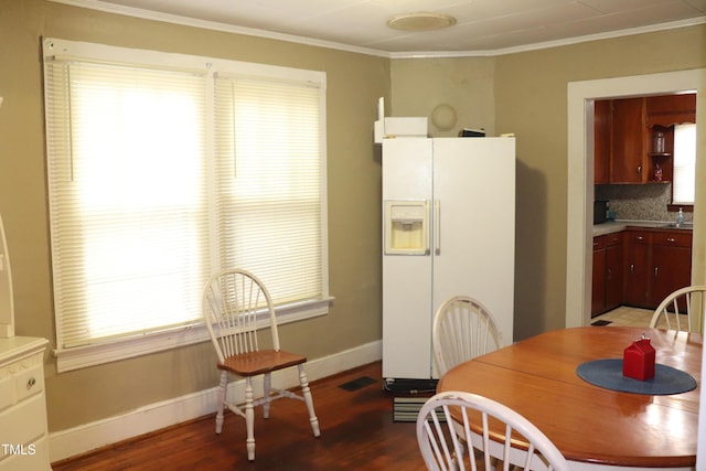 dining area with wood-type flooring and ornamental molding