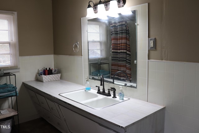 bathroom featuring vanity and tile walls