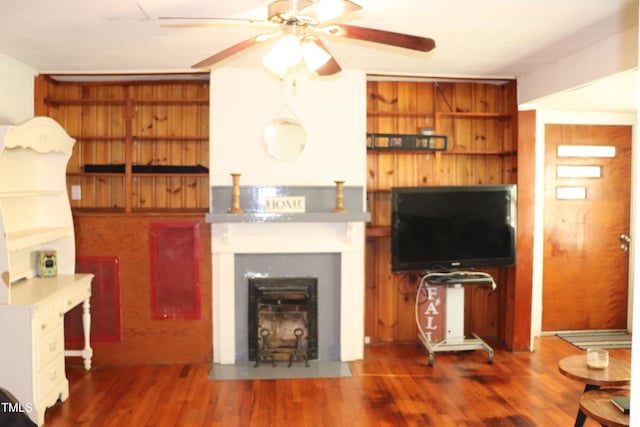 living room with dark wood-type flooring and wooden walls