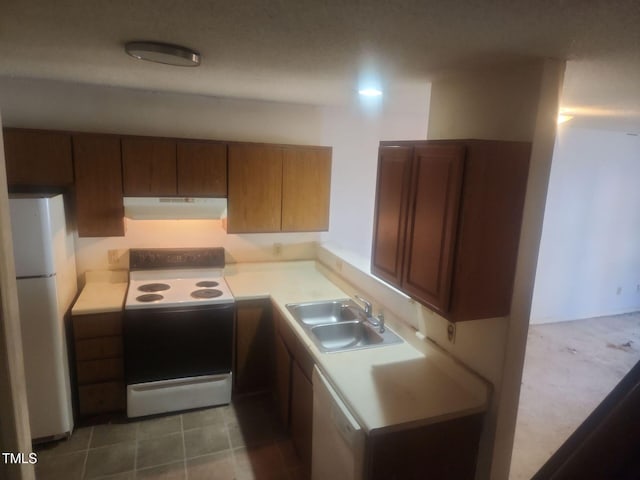 kitchen featuring sink, white fridge, and electric range oven