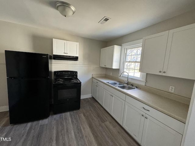 kitchen featuring dark wood-type flooring, white cabinets, black appliances, and sink