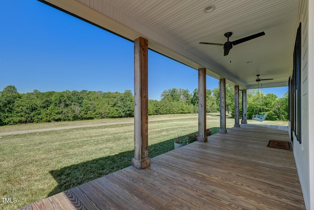 deck featuring ceiling fan and a yard