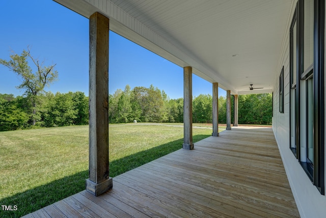 wooden terrace with covered porch and a yard