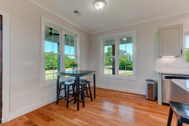 dining space featuring light wood-type flooring and ornamental molding