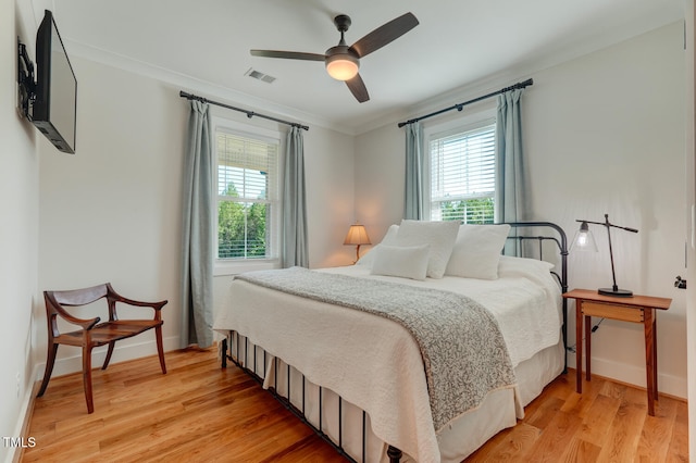 bedroom with ceiling fan, light hardwood / wood-style floors, and crown molding