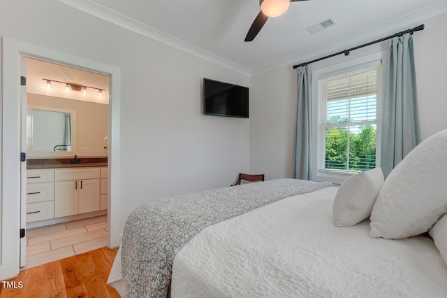 bedroom with connected bathroom, ceiling fan, sink, light hardwood / wood-style flooring, and ornamental molding