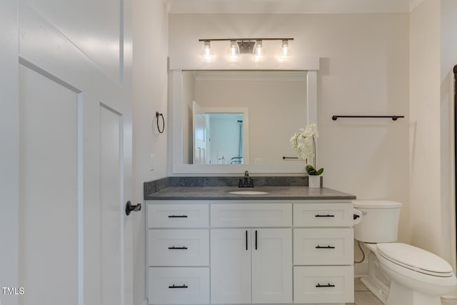 bathroom with tile patterned flooring, vanity, and toilet