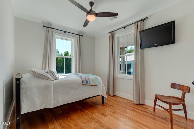 bedroom featuring ceiling fan, light wood-type flooring, and ornamental molding