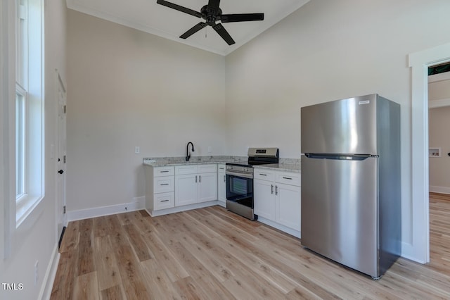 kitchen featuring light stone countertops, ceiling fan, stainless steel appliances, light hardwood / wood-style flooring, and white cabinets