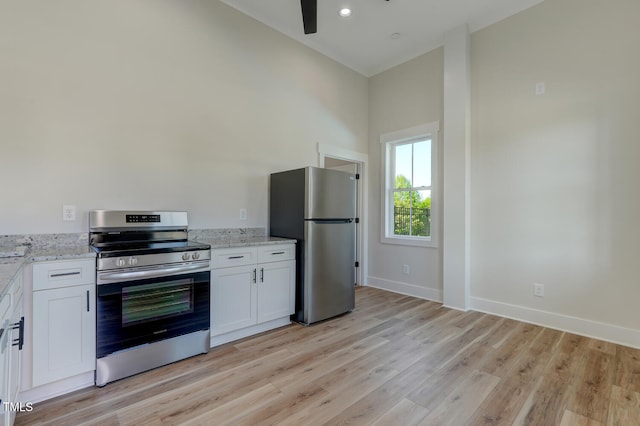 kitchen featuring light stone countertops, white cabinetry, ceiling fan, and stainless steel appliances