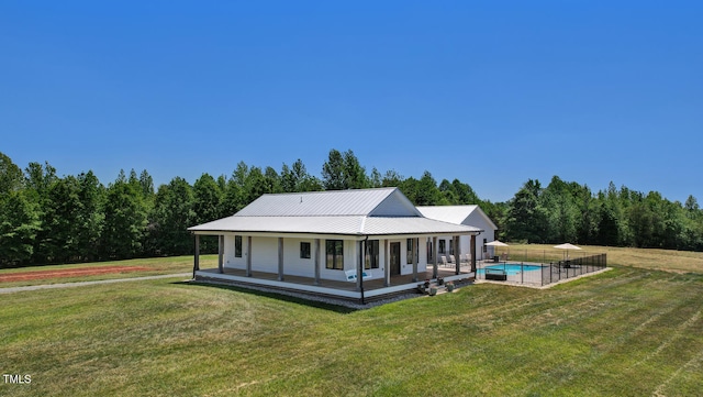 rear view of property featuring a lawn and covered porch