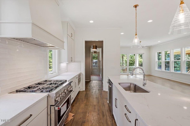 3302.5 Hall Pl, Raleigh, NC 27607 - kitchen featuring appliances with stainless steel finishes, a sink, white cabinetry, decorative backsplash, and custom range hood