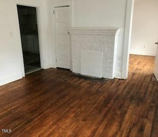 unfurnished living room featuring dark hardwood / wood-style flooring